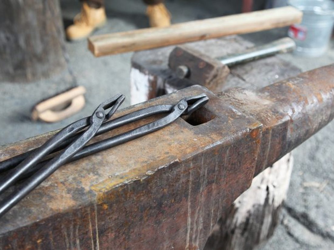 Hand-forged tongs resting on the anvil